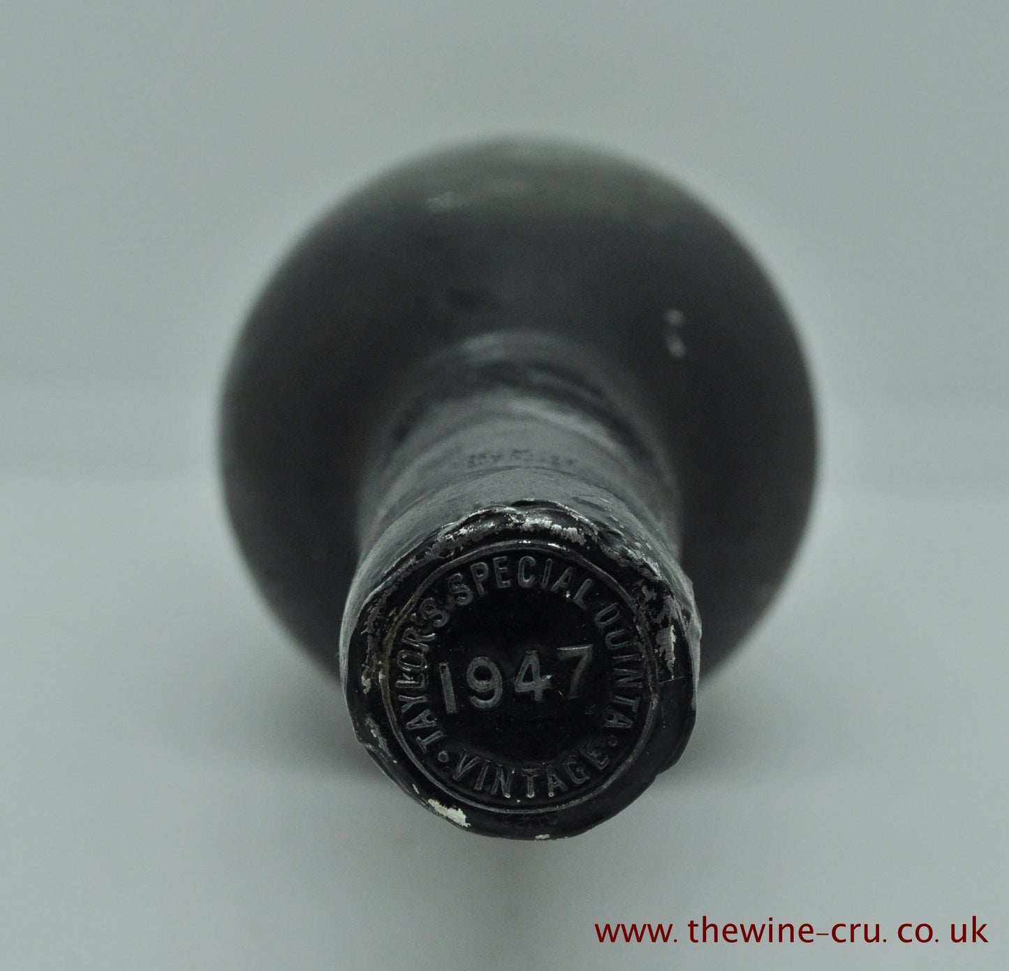 Photo of the capsule. 1947 vintage port wine. The bottle is label-less, but the vintage and name are visible on the capsule. The wine level is top shoulder. Immediate delivery. Free local delivery. Gift wrapping available.