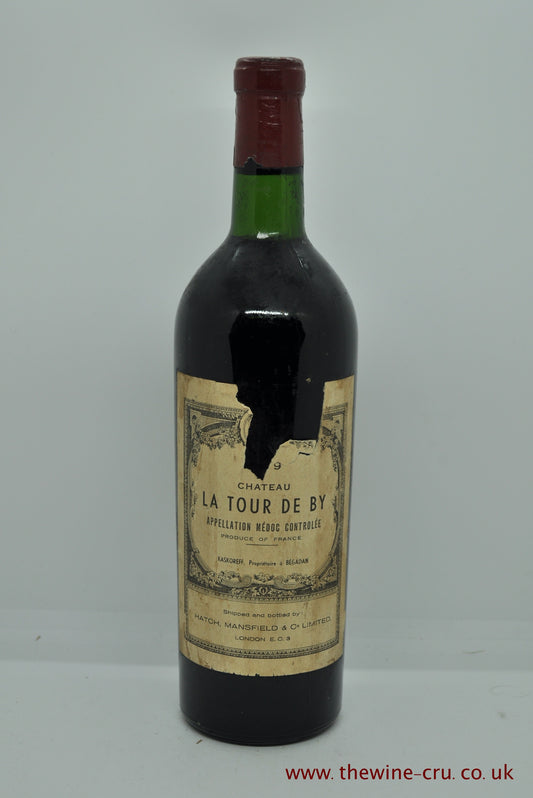 a bottle of vintage red wine from an unknown vintage. Chateau La Tour De By. France, Bordeaux. The bootle has  good capsule and the level is base of neck. The label has a piece missing where the vintage is. It is 19?9. I believe from the label style that it is either 1949 or 1959 with an outside chance that it could be 1969. Immediate delivery. Free local delivery. Gift wrapping available.