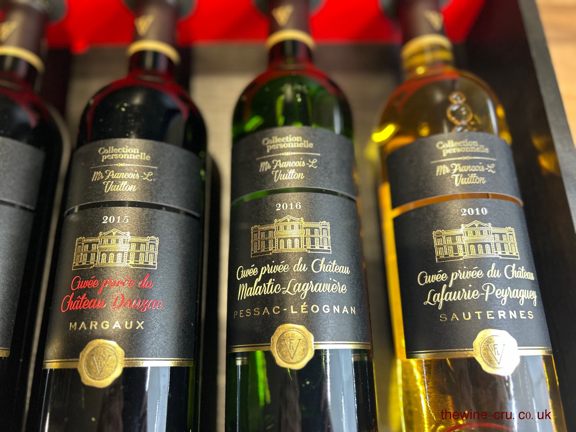 Close up of the other three bottles in a branded wooden case.