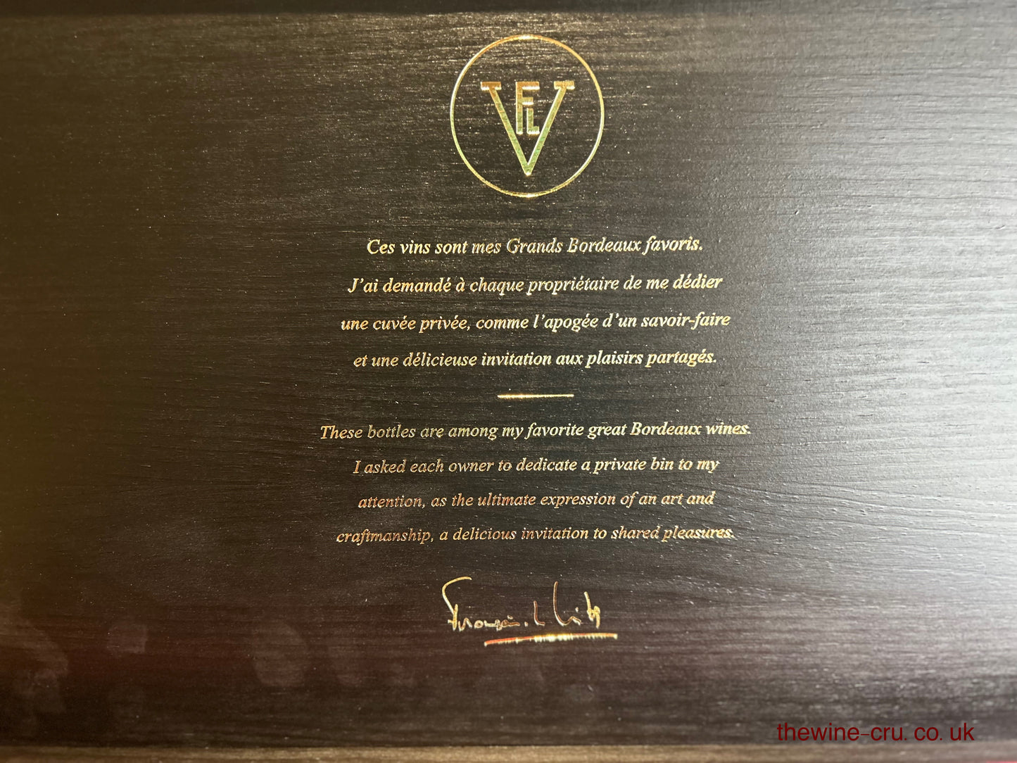 Wooden wine box with gold text and logo on a dark wood background