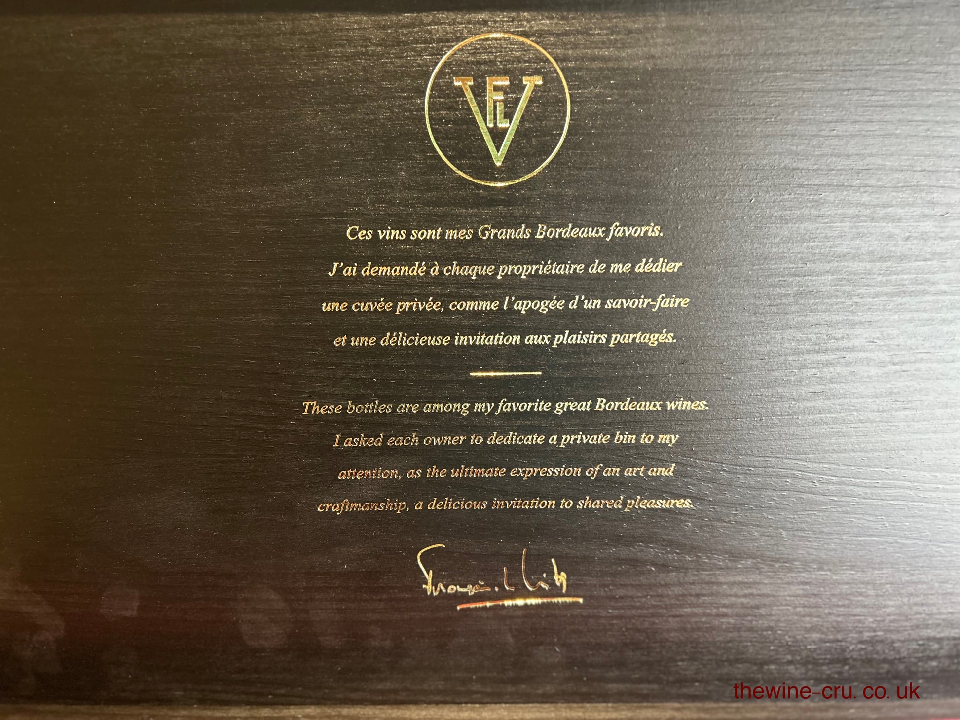 Wooden wine box with gold text and logo on a dark wood background