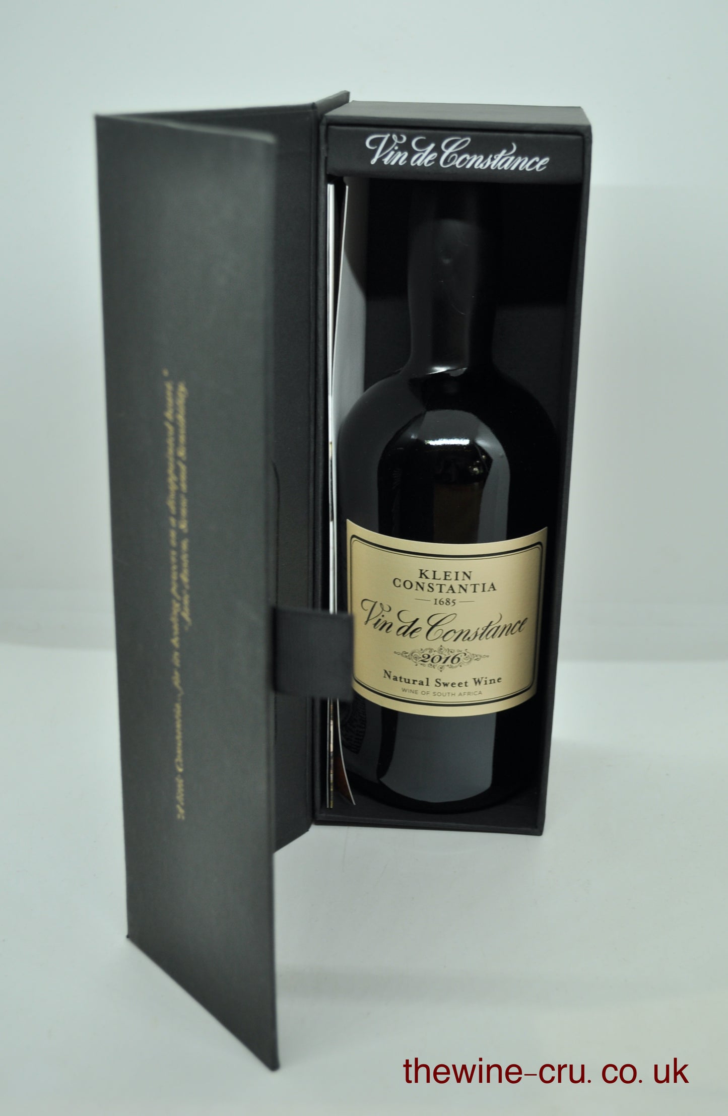 A bottle of Klein Constantia Vin de Constance natural sweet wine presented in a black gift box with the door open, photographed against a light gray background.