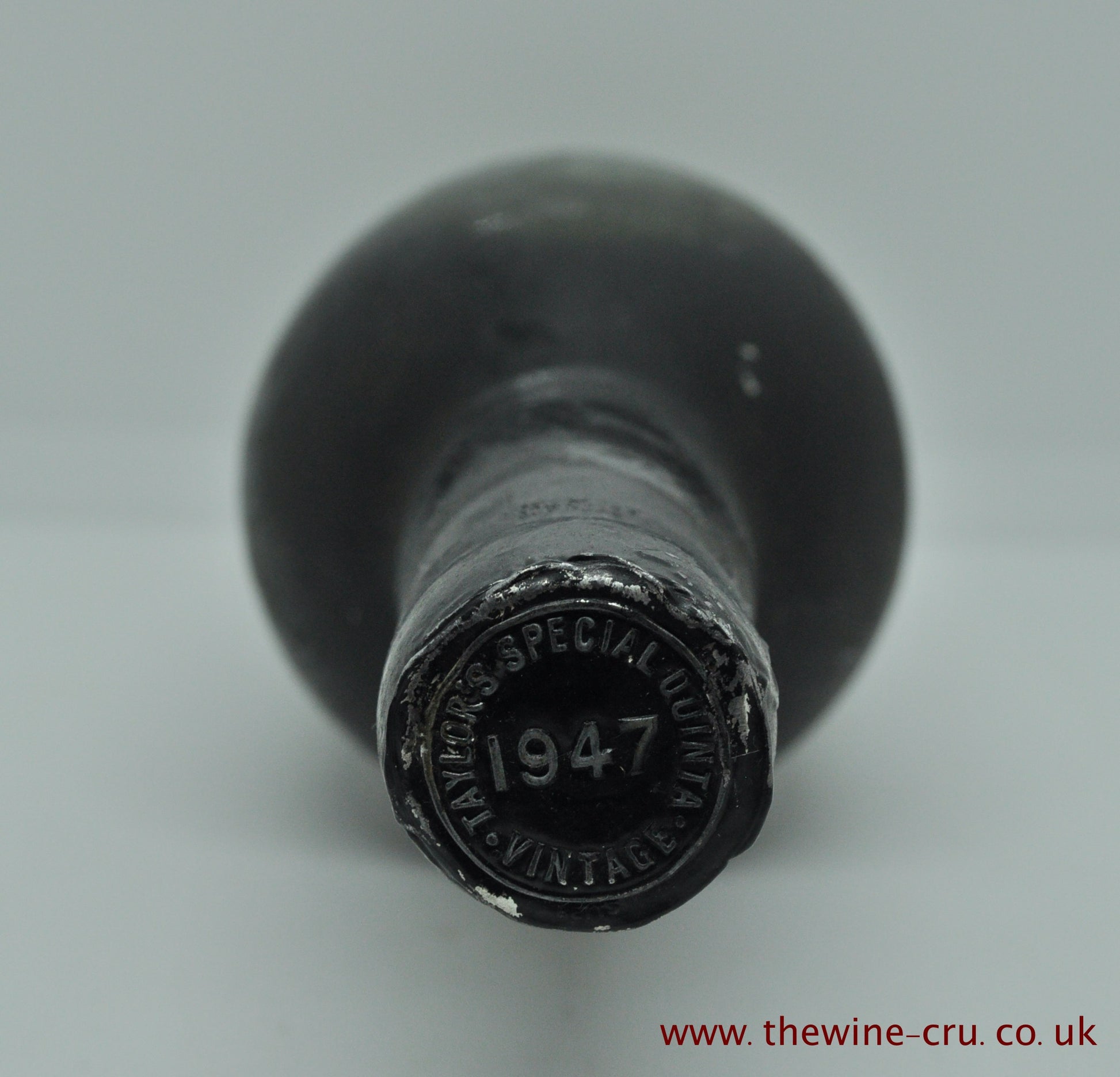 Photo of the capsule. 1947 vintage port wine. The bottle is label-less, but the vintage and name are visible on the capsule. The wine level is top shoulder. Immediate delivery. Free local delivery. Gift wrapping available.